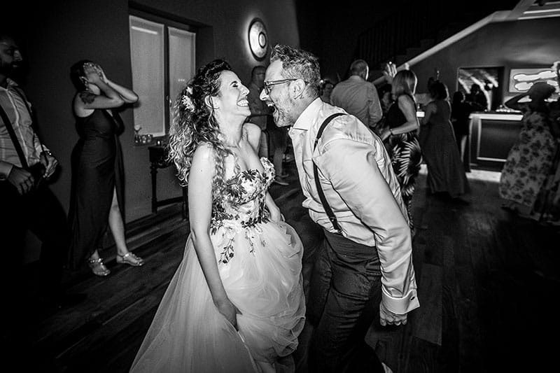 sposi che ridono mentre ballano. Scatto di Mario Amelio Fotografo di matrimonio reportage.