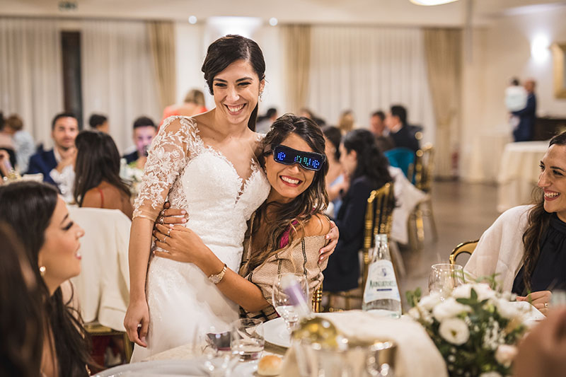 sposa che abbraccia un'invitata durante la cena nuziale