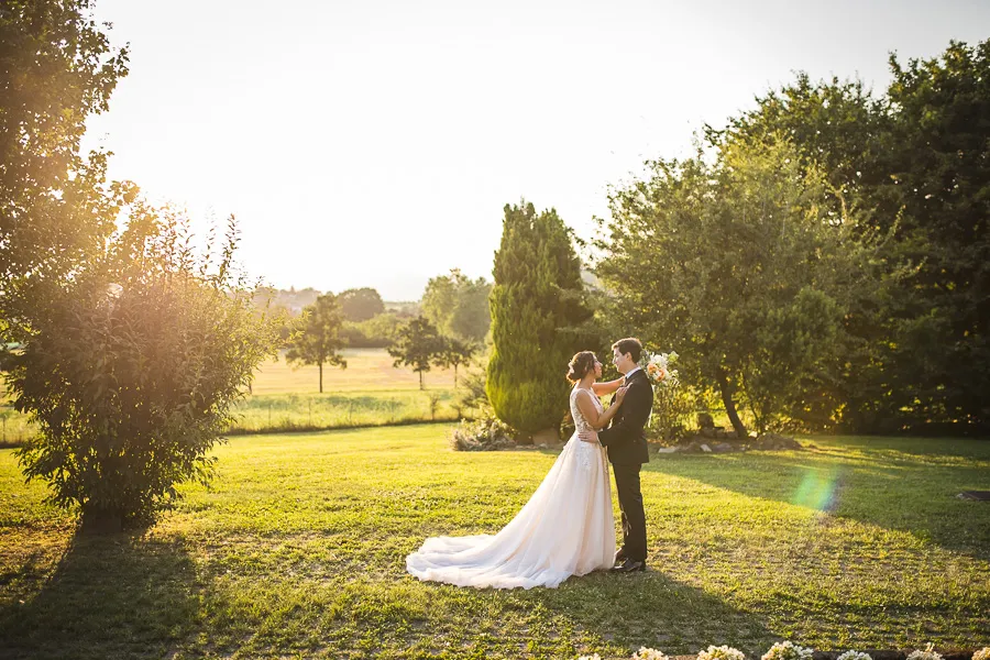 Gli sposi si abbracciano al tramonto nel giardino della Cascina dei Frati, Brusaporto