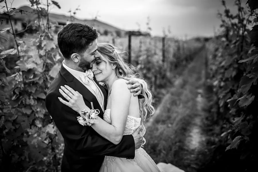 Abbraccio emozionante tra gli sposi nei vigneti di Borgo Santa Giulia tenero abbraccio tra gli sposi nei vigneti di Borgo Santa Giulia, immersi in un’atmosfera romantica
