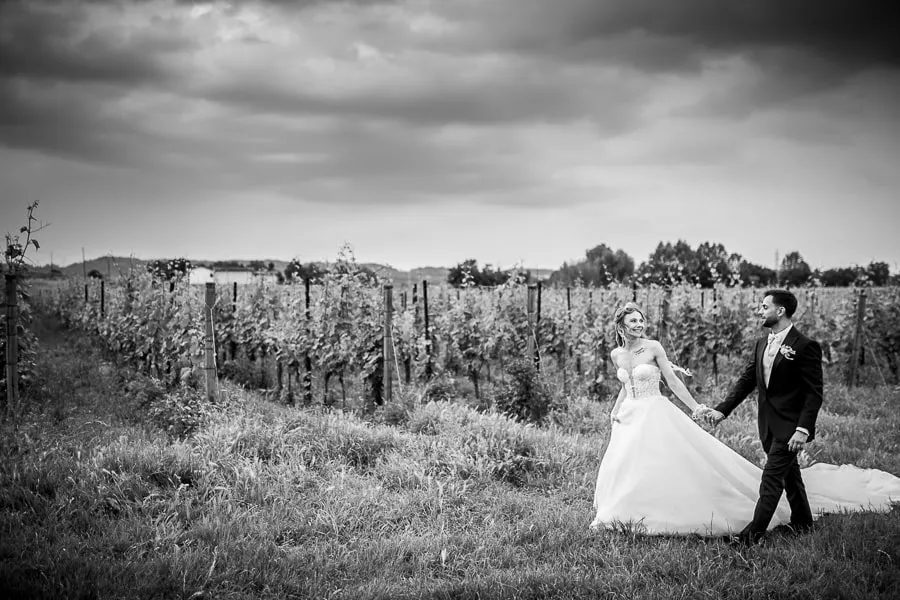 Passeggiata romantica tra i vigneti di Borgo Santa Giulia Fotografo matrimonio Brescia cattura gli sposi mentre passeggiano mano nella mano tra i vigneti di Borgo Santa Giulia, con un cielo suggestivo sullo sfondo