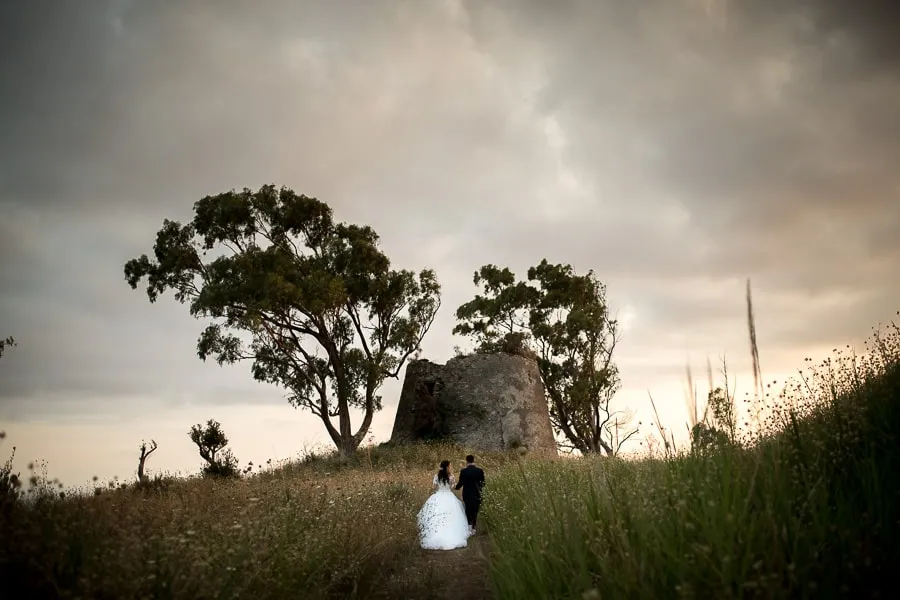 Fotografo matrimonio Lamezia Terme, sposi che camminano su una collina al tramonto