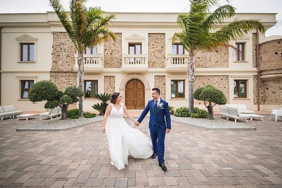 Coppia di sposi felice cammina nel cortile di Tenuta Balzano, una suggestiva location matrimonio Catanzaro immersa nella natura
