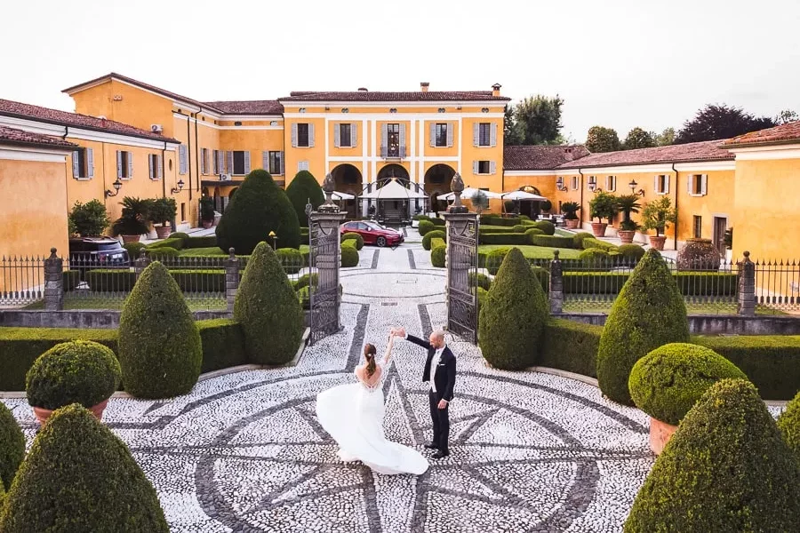 Sposi che ballano nel piazzale di una villa storica a Brescia, un esempio di come scegliere fotografo matrimonio Brescia per immortalare momenti unici.