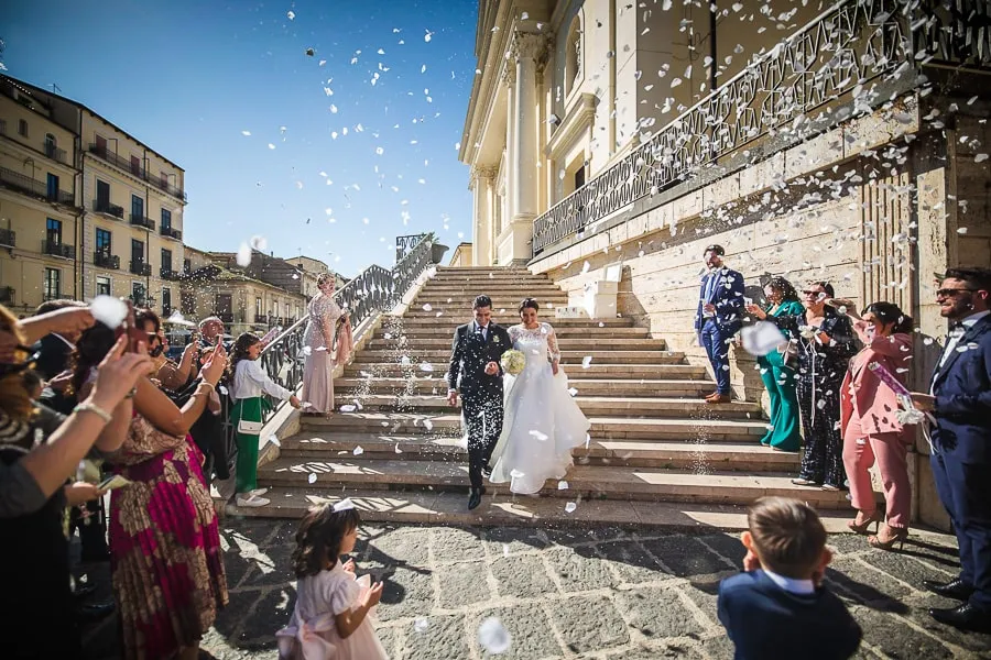 Gli sposi escono dalla chiesa tra petali e applausi, un momento perfetto per chi vuole scegliere fotografo matrimonio Lamezia Terme