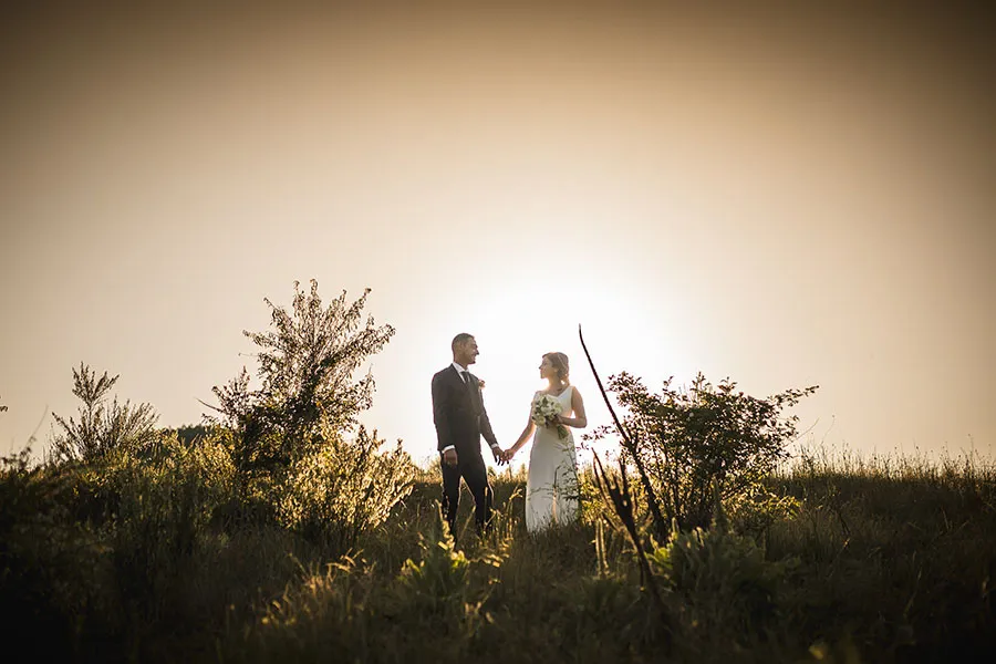 Sposi su una collina al tramonto, immersi in un'atmosfera romantica, un esempio delle nuove tendenze fotografia matrimonio Bergamo per il 2025.