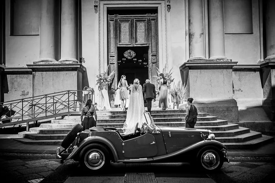 Sposa scende dall’auto d’epoca davanti alla chiesa nel cuore di Catanzaro durante foto matrimonio spontanee Catanzaro