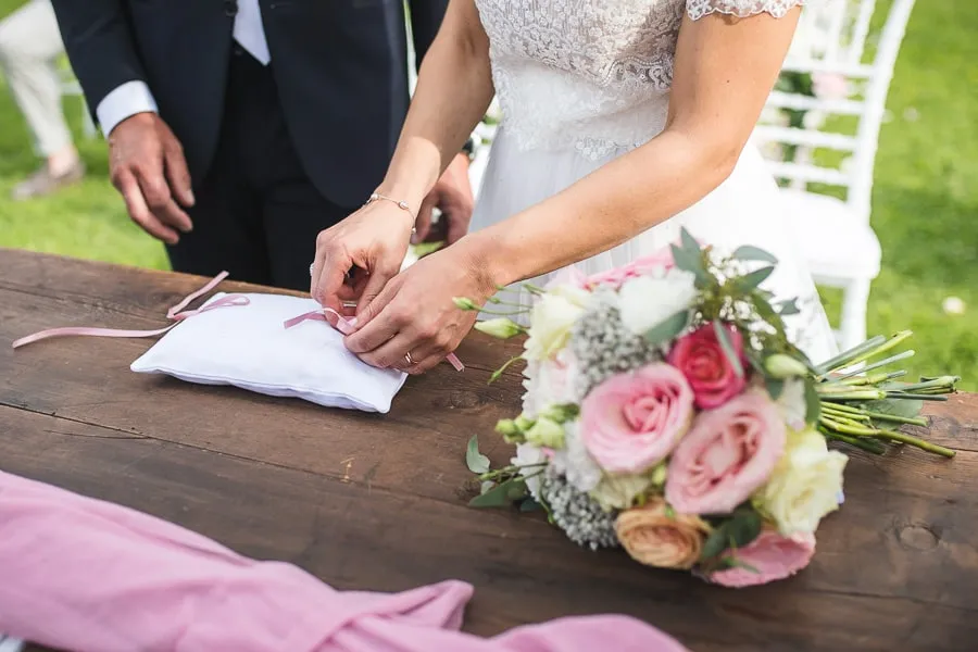 Dettaglio degli anelli nuziali e bouquet floreale curato da fornitori matrimonio Bergamo