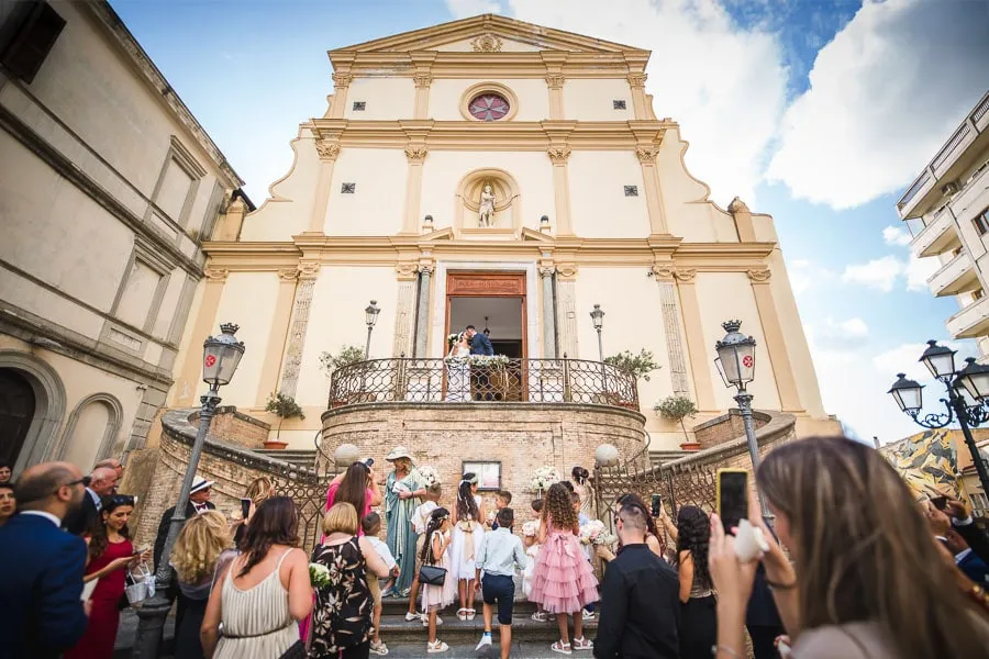 Uscita degli sposi dalla chiesa con lancio del riso tra amici e parenti durante foto matrimonio spontanee Catanzaro