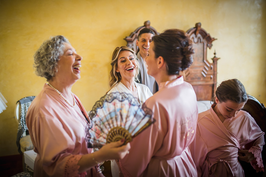 Momenti di gioia tra la sposa e le invitate durante i preparativi, scegliere fotografo matrimonio Bergamo