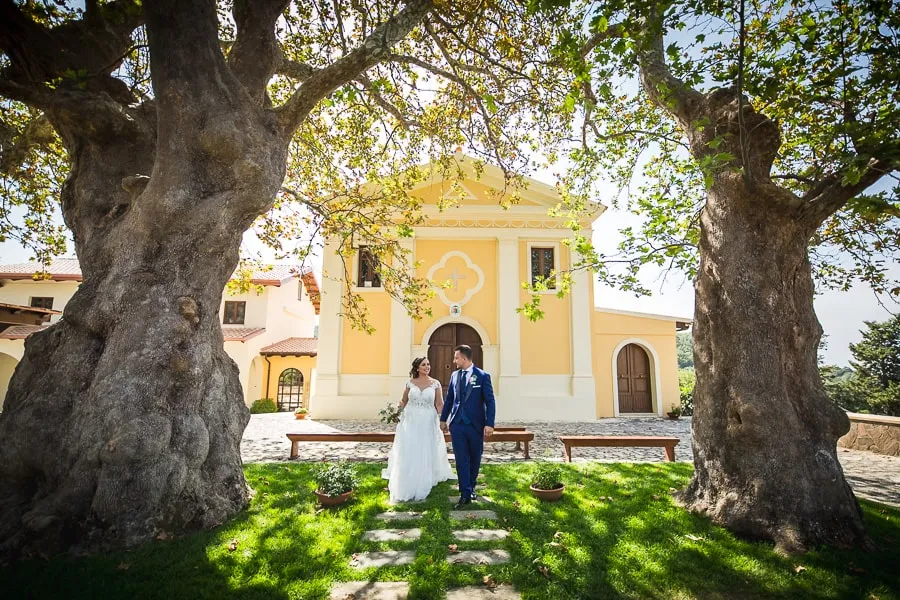 Coppia di sposi cammina nel giardino antistante il santuario di Dipodi a Lamezia Terme, esempio perfetto del valore nel prezzo fotografo matrimonio Lamezia Terme