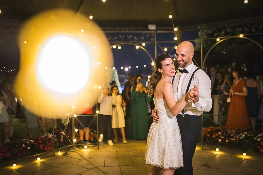 primo ballo sposi circondati da luci e amici durante foto matrimonio spontanee Brescia