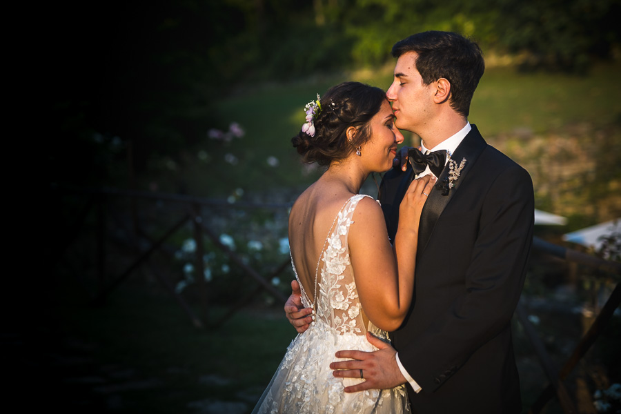 Sposi abbracciati al tramonto in un romantico ritratto, scegliere fotografo matrimonio Bergamo