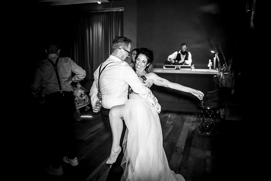 Sposi si divertono sulla pista da ballo durante la festa, esempio di momento autentico catturato grazie alla scelta fotografo matrimonio Bergamo