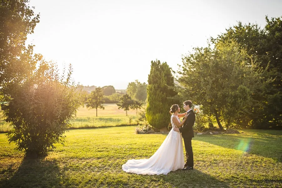 Coppia di sposi si abbraccia dolcemente al tramonto, valorizzata dalla scelta fotografo matrimonio Bergamo.