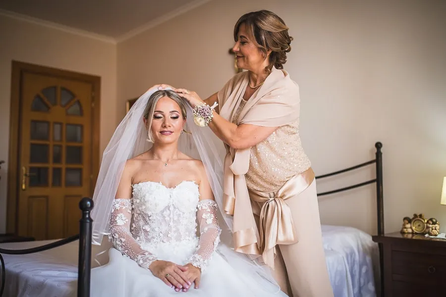 La mamma della sposa sistema il velo con dolcezza, momento prezioso per la selezione foto matrimonio