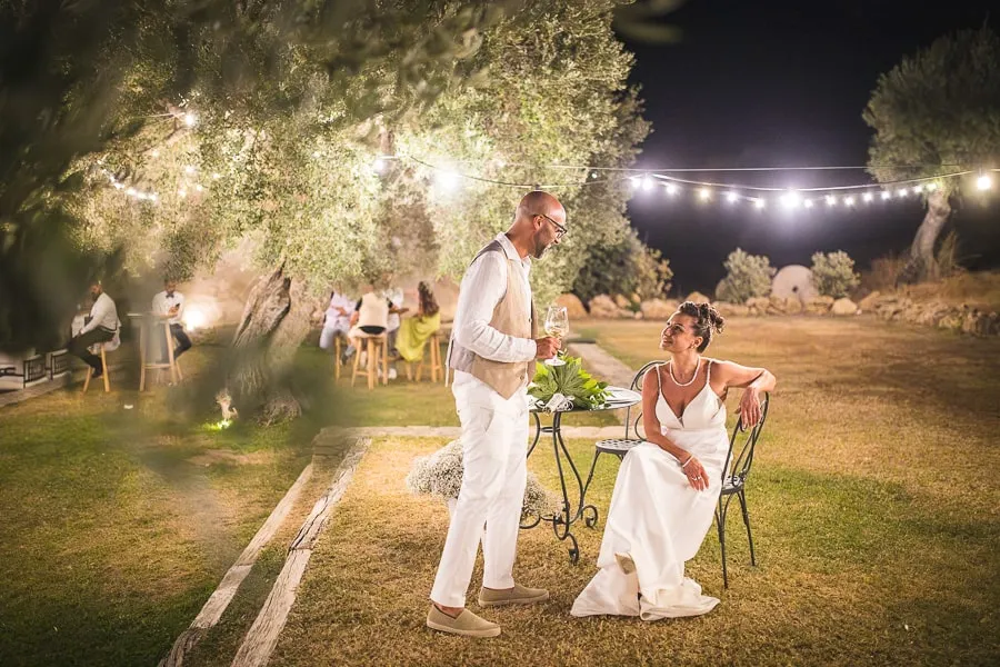 Sposi rilassati durante il ricevimento serale all’aperto, un momento perfetto per la selezione foto matrimonio