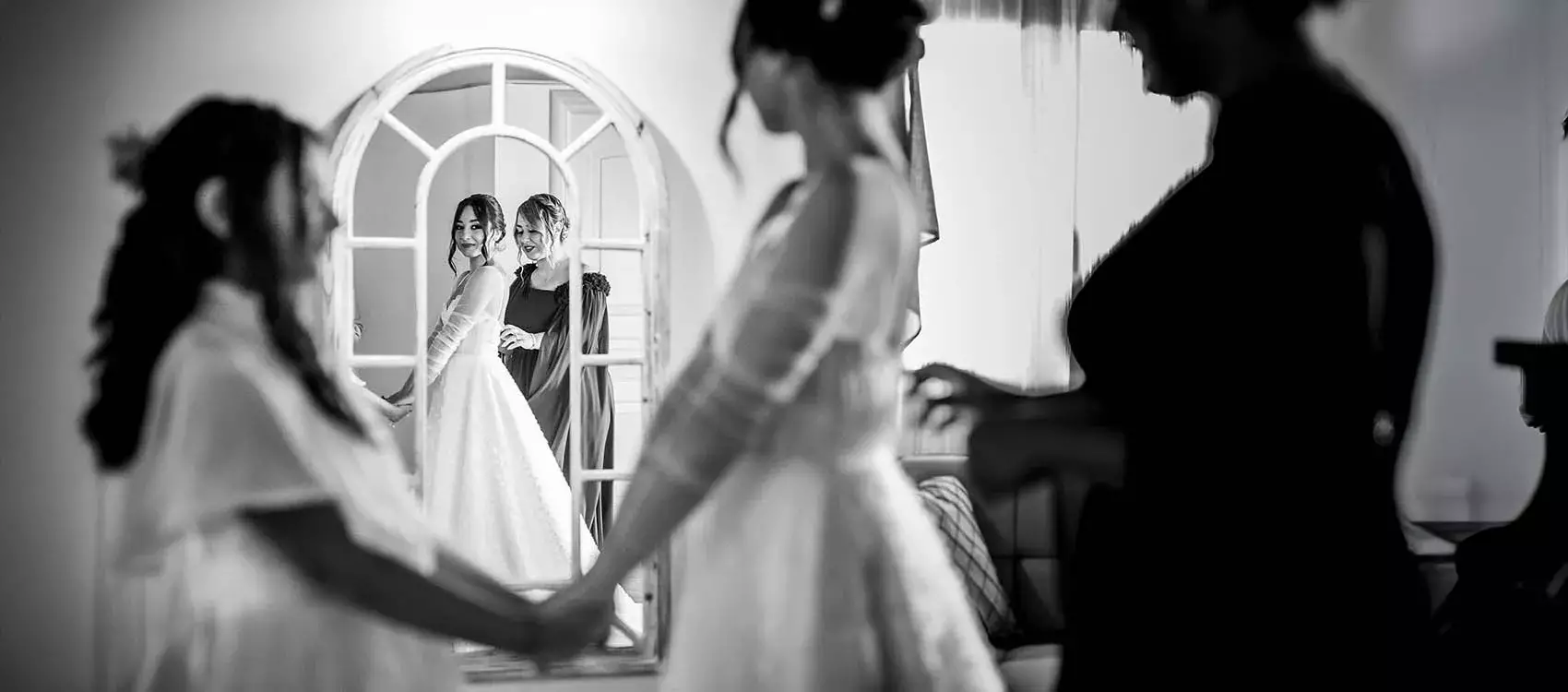 damigella che aiuta la sposa ad abbottonare l'abito